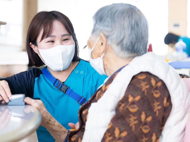 笑顔で話す女性たち スタッフイメージ スタッフが入居者と親しげに会話しています。温かいコミュニケーションが大切です。