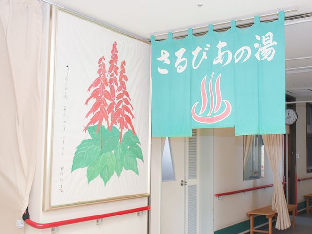 暖簾がある室内 廊下 廊下には色鮮やかな暖簾が掛かっており、入居者の日常に彩りを添えています。明るい空間が広がっています。