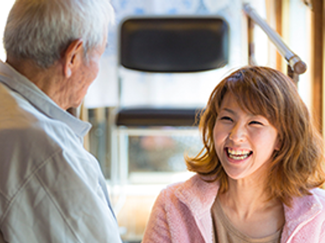 笑顔のスタッフと利用者の会話 スタッフイメージ 温かな雰囲気の中で、利用者とスタッフが笑顔でコミュニケーションをとっています。