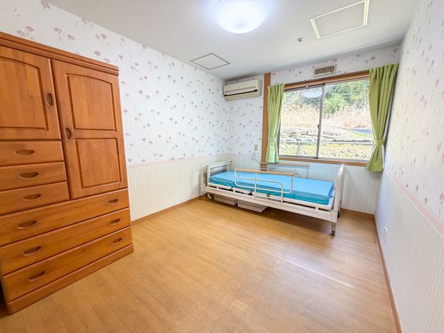 居室 居室 明るい自然光が入る居室です。温かみのある木製家具が配置されています。