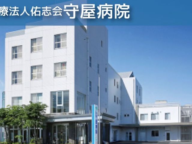 白い建物の外観 外観   白を基調とした建物が青空の下に建っています。正面にはガラス張りの出入口があり、明るい印象です。
