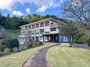 緑に囲まれた建物の外観  