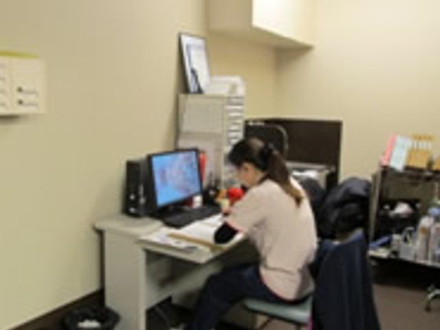 デスク作業の様子部屋 スタッフイメージ スタッフがデスクで作業している仕事環境です。快適に働ける落ち着いた空間です。