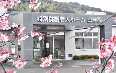桜の前に建物の外観