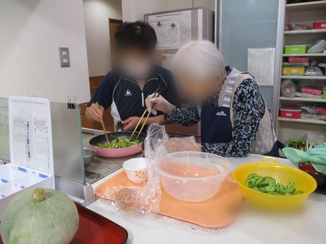 料理中の様子 キッチン 利用者とスタッフが協力して料理を楽しんでいます。温かな交流が働く環境を作り出しています。