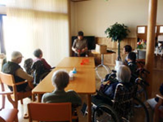 自然光が差し込む部屋 リビング 自然光がたっぷり入る明るい空間で、入居者たちが椅子に座って活動を楽しんでいます。