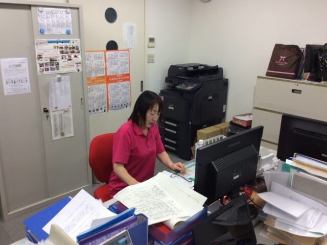職員が働くオフィス スタッフイメージ 職員がオフィスで書類を整理しています。働きやすい環境が整っています。
