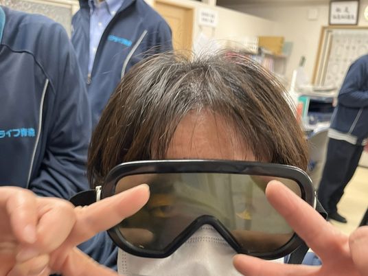 ゴーグルを着けた職員と利用者の室内  