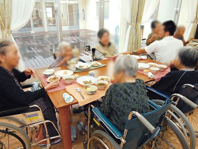 交流を楽しむダイニング ダイニングルーム 車椅子にも対応したテーブルで、入居者の皆さんが食事を楽しんでいます。自然光が差し込む明るい環境です。