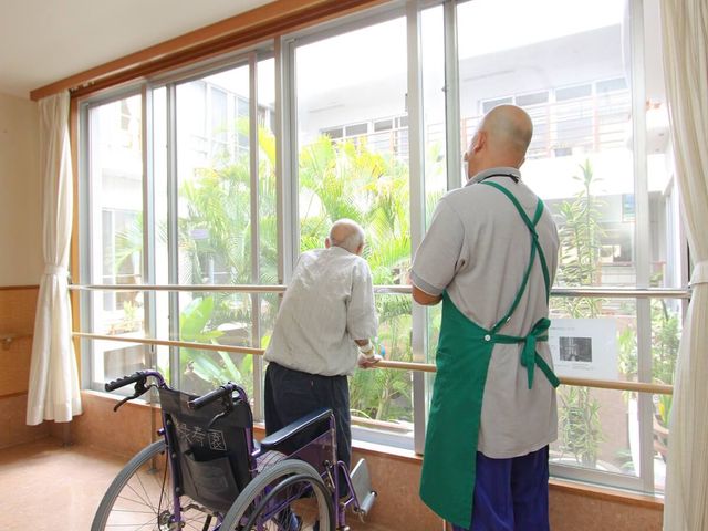 自然光が入る廊下 廊下 手すり付きの大きな窓から陽光が差し込み、安心できる空間になっています。