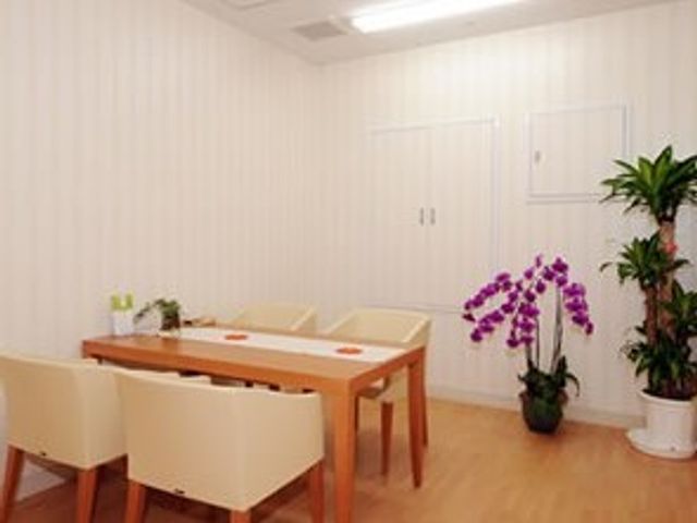 清潔な白壁の居室 談話室 ゆったりとした椅子が並ぶ明るい居室です。観葉植物がアクセントになり、穏やかな時間を過ごせる空間が広がっています。