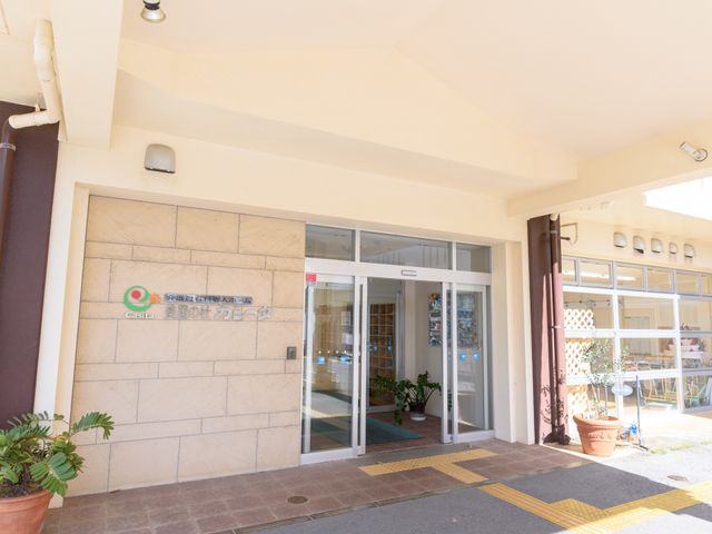 エントランスの外観 出入口 明るい陽光が差し込む、開放的なエントランスです。手動式の扉を通り、快適な空間へとご案内いたします。