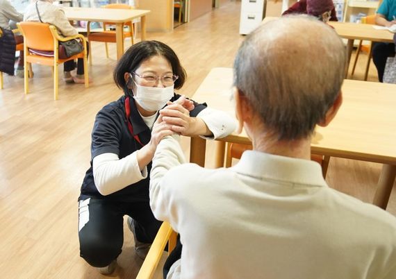 スタッフと利用者の手をつなぐ場面
