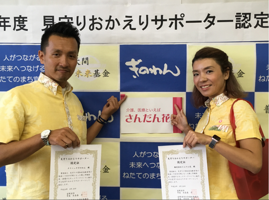 認定証を持つ男女の記念撮影  