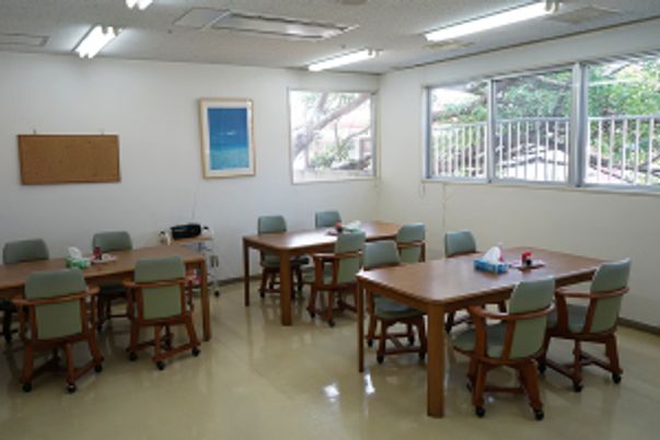 明るい共有テーブルが並ぶ部屋