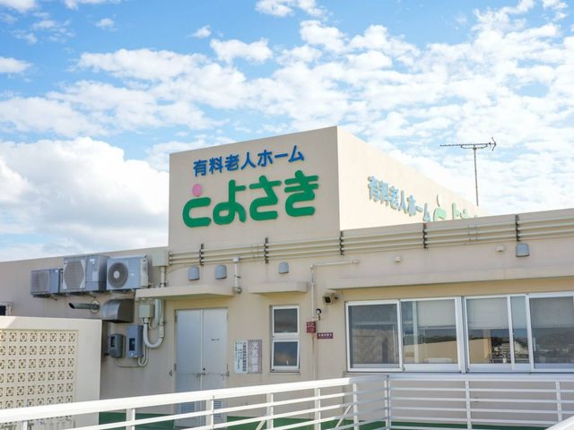 「こよさき」の看板 看板 有料老人ホーム「こよさき」の看板が見えます。青空が広がる中で、建物の屋上に設置されています。