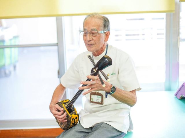 楽器演奏中の男性 リビング 自然光が差し込む明るい空間で、寛ぎながら演奏を楽しむことができます。学びや交流の場として最適です。
