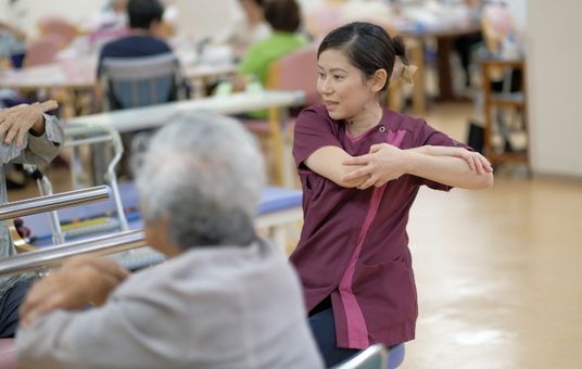 笑顔のスタッフと利用者の機能訓練室  