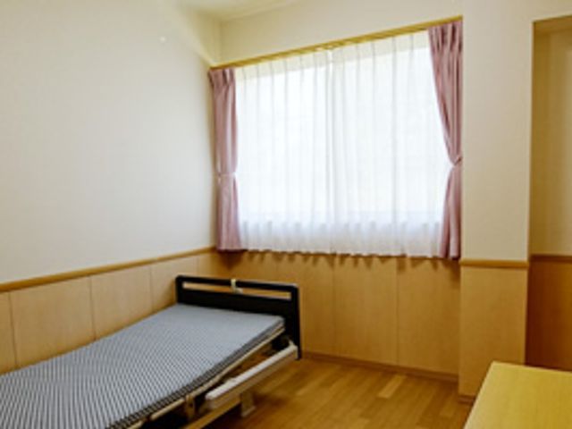 ベッドがある居室 居室 自然光が差し込む居室は、温かみのある色合いの空間で、落ち着いた休息を提供します。