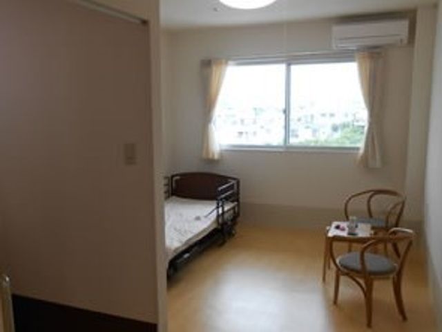 居室のベッドと椅子 居室 日当たりが良く、清潔な個室です。個々の快適な空間で、ゆったりとした時間を過ごせます。