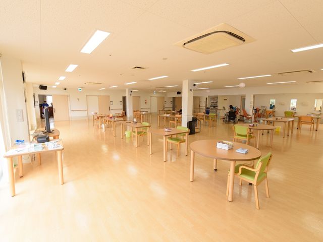 広々とした明るい食堂 共有スペース ゆったりとした空間の食堂は、明るく開放的な雰囲気で、利用者がリラックスして過ごせる設計になっています。各テーブルには椅子が配され、数人が集まることができ、交流の場としても機能しています。
