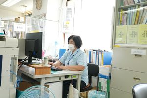 机で作業中の人物事務室