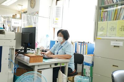 机で作業中の人物事務室