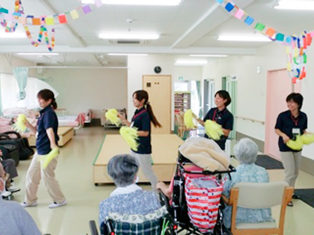 楽しむ入居者たち共有スペース 共有スペース 広いスペースでスタッフと入居者が一緒に楽しく活動できる場です。明るい雰囲気が広がります。