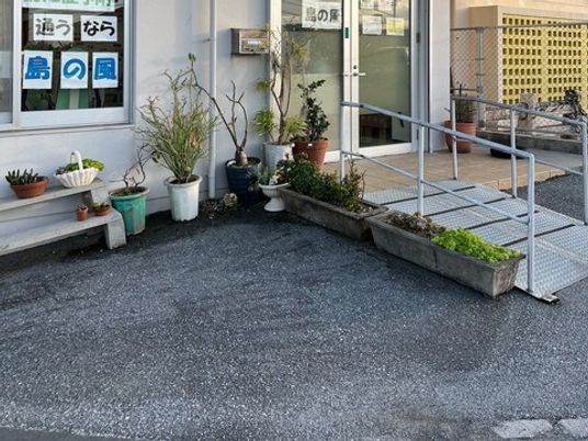植木が並ぶ入口前の外観  