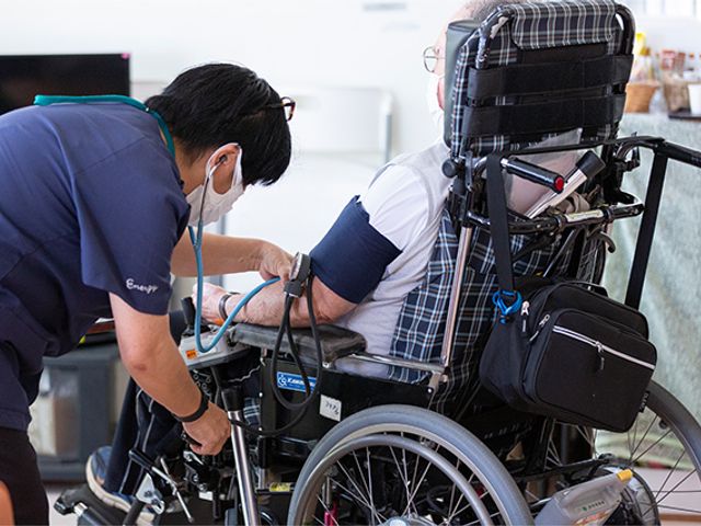 車椅子利用者と看護職員 スタッフイメージ 看護職員が車椅子の方をサポートしている様子です。安心して働ける環境が整っています。