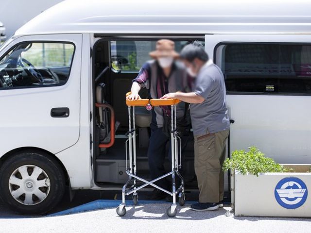 介護者と利用者の乗降場面 フロント 介助者が利用者をサポートし、安全な乗降をサポート。信頼と安心感が伝わります。