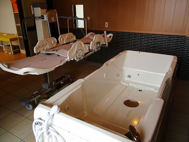 入浴用ベッドと浴槽の浴室 浴室   入浴用のベッドと大きな浴槽があり、介助しやすい設備が整っています。安全に配慮した入浴支援を行いやすい環境です。
