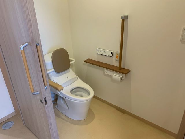 手すり付きのトイレ トイレ 手すりが設置されたトイレで、安全に配慮しています。清潔感があり、落ち着いた空間です。