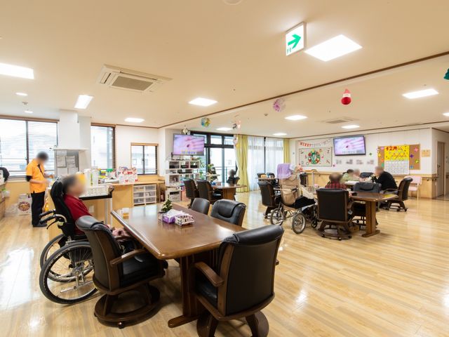ゆったりした食堂の風景 食堂 広々とした食堂で、利用者様がゆっくりと食事を楽しんでいる様子です。スタッフが温かいサポートを提供しており、明るく穏やかな雰囲気が感じられます。