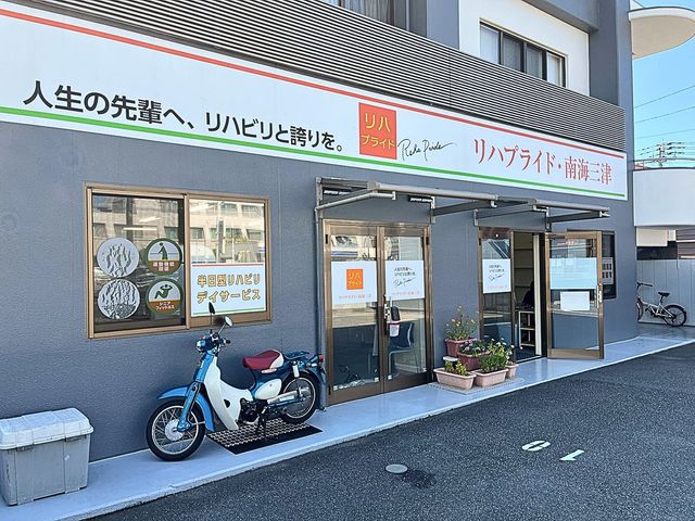 建物外観 外観 鮮やかな看板が目を引く建物の前です。木陰に置かれた自転車が周囲の穏やかな雰囲気を醸し出しています。