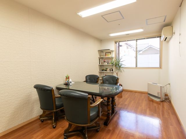 明るい居室の空間 談話室 落ち着いた雰囲気の居室です。木目調の床と丸テーブルが、温かな対話の場を提供しています。