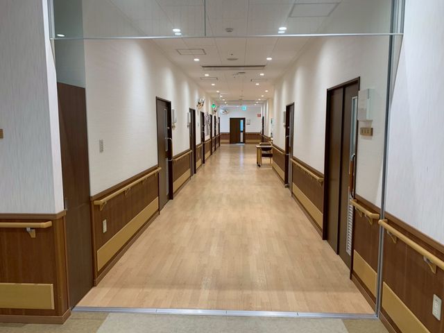 安全設計の廊下 廊下 手すりが設置された、広くて安全な歩行スペースです。明るい照明が行き届いています。