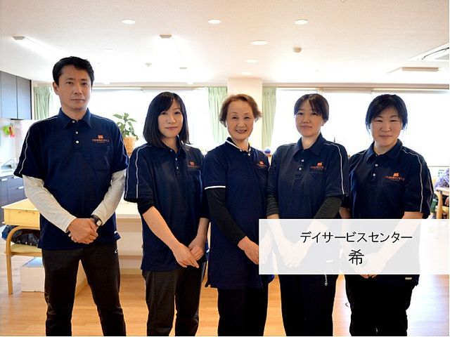 スタッフ集合のラウンジ ラウンジ   明るいラウンジで、スタッフの皆さんが並んで立っています。利用者の方が過ごしやすい雰囲気が伝わる空間です。