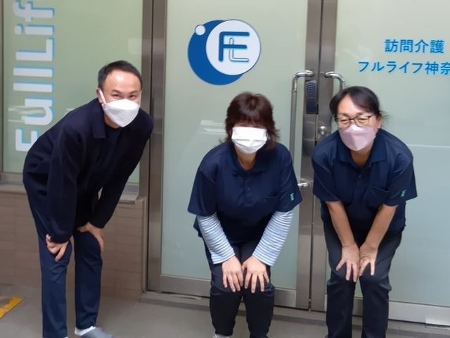 訪問介護のスタッフ スタッフイメージ   入口前で3人のスタッフが並び、丁寧にあいさつしている様子です。訪問介護の現場で、協力しながら働く雰囲気が伝わります。