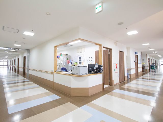 清潔感ある広々廊下 通路 明るく開放的な廊下はスタッフの動きやすさを考慮した設計です。職員が笑顔で業務に従事しており、活気が感じられます。
