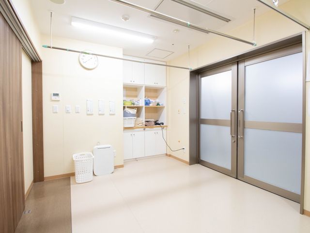 清潔な廊下と自動ドア 物干し竿 手すり完備の広々とした廊下は、車椅子利用者も安心して移動できる設計です。自動式のドアは出入りの容易さを考慮しています。