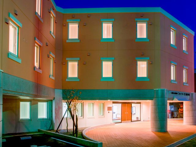 温かみのある外観 外観 夜間でも温かさが感じられる明るい建物の正面です。優しい照明が安心感を与えています。