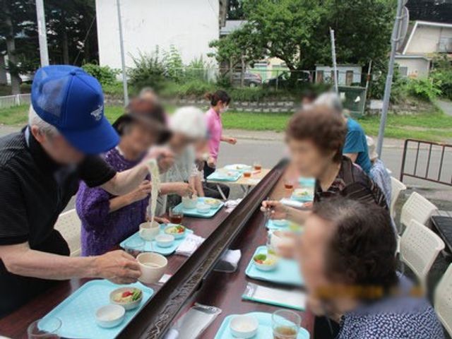 外での活動 ダイニングルーム 和やかな雰囲気で、外での食事を楽しむ様子です。テーブルには食事が並んでいます。
