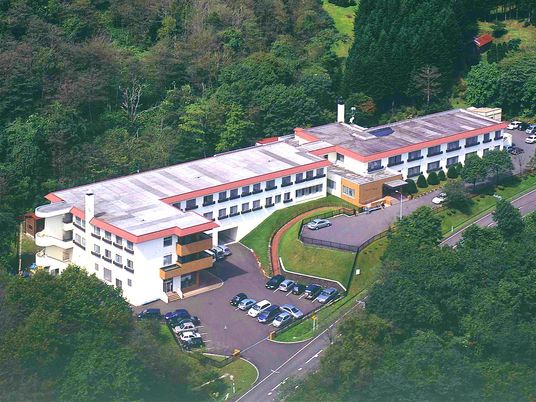 森に囲まれた建物外観  