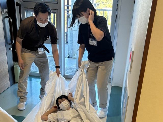 廊下で移動介助する職員  