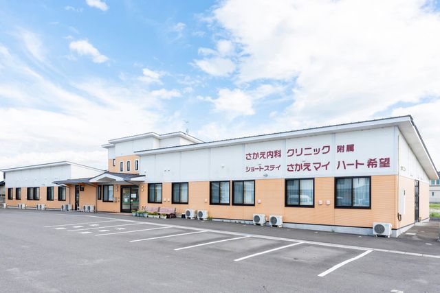清潔で広々とした建物外観 外観 すっきりとした駐車スペースがあり、明るい空の下で穏やかな雰囲気を感じられます。