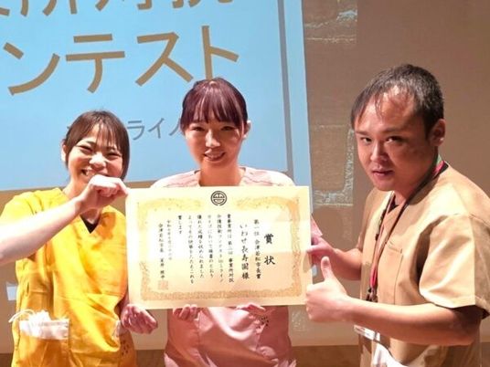表彰状を持つスタッフ  