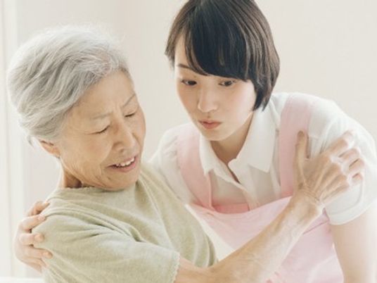 スタッフがおばあさんを支える