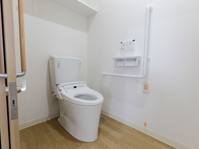 バリアフリートイレ トイレ 手すり付きの清潔なトイレは、安全に利用できる工夫が施されています。快適な生活をサポートする設備が整っており、働きやすい環境があります。