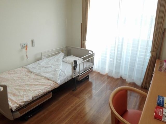 自然光が差し込む居室 居室 明るい空間で、快適に過ごせるよう工夫されています。ベッドやチェアが置かれ、リラックスしやすい雰囲気です。